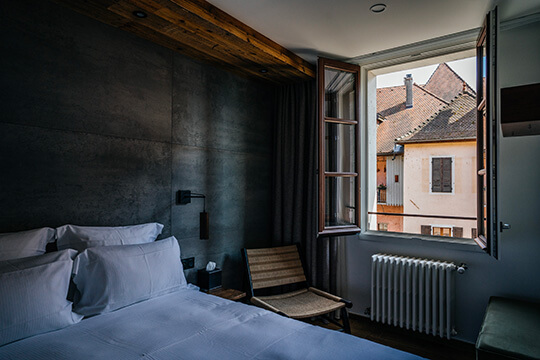 Un lit près d'une fenêtre dans l'hôtel de l'Auberge du Lyonnais
